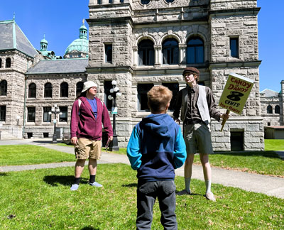 Parliamentary Players perform behind the BC Parliament Buildings