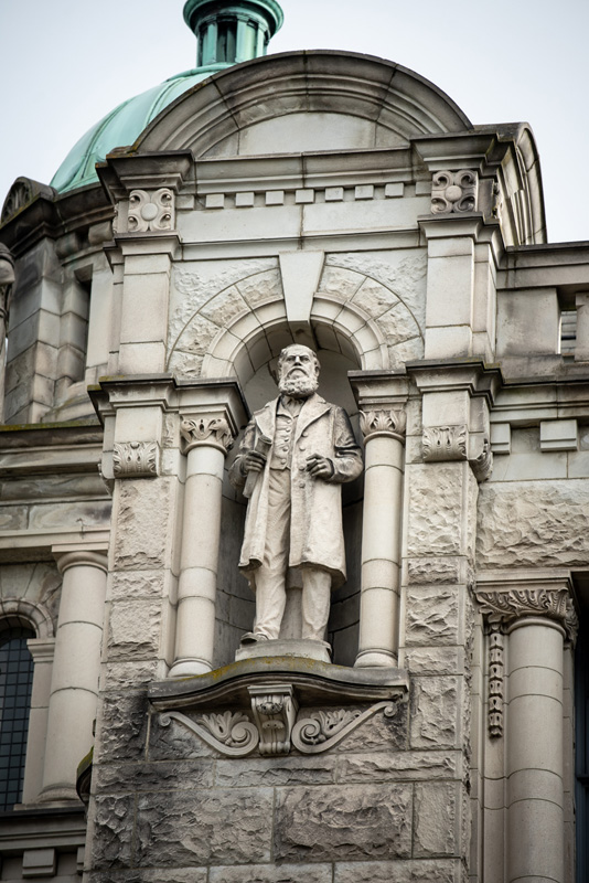 This statue of Sir Anthony Musgrave is located on the exterior of the Legislative Library.